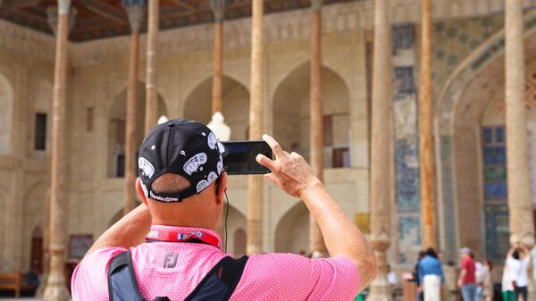 Турист фотографирует достопримечательность  - Sputnik Ўзбекистон