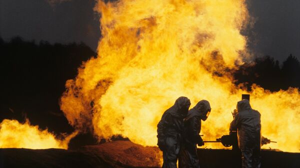 Работники службы по укрощению открытых нефтяных и газовых фонтанов во время тушения возгорания на объекте нефтяной отрасли - Sputnik Ўзбекистон