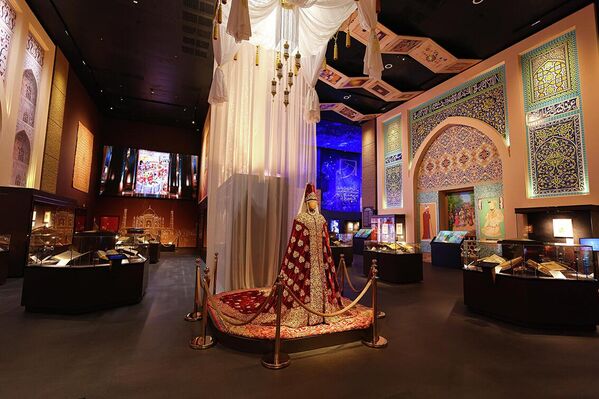 Tarixiy asarlar bilan o‘ralgan va an’anaviy sharqona koshinlar bilan bezatilgan boy bezatilgan marosim yoki to‘y libosi bilan jihozlangan ko‘rgazma xonasi - Sputnik O‘zbekiston