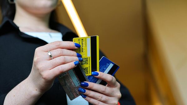 Девушка с кредитной картой в руке перед ноутбуком - Sputnik Ўзбекистон