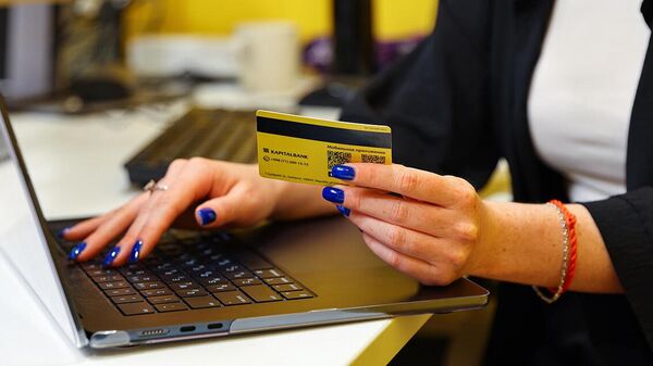 Devushka s kreditnoy kartoy v ruke pered noutbukom - Sputnik O‘zbekiston