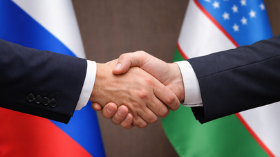 Рукопожатие на фоне флагов России и Узбекистана