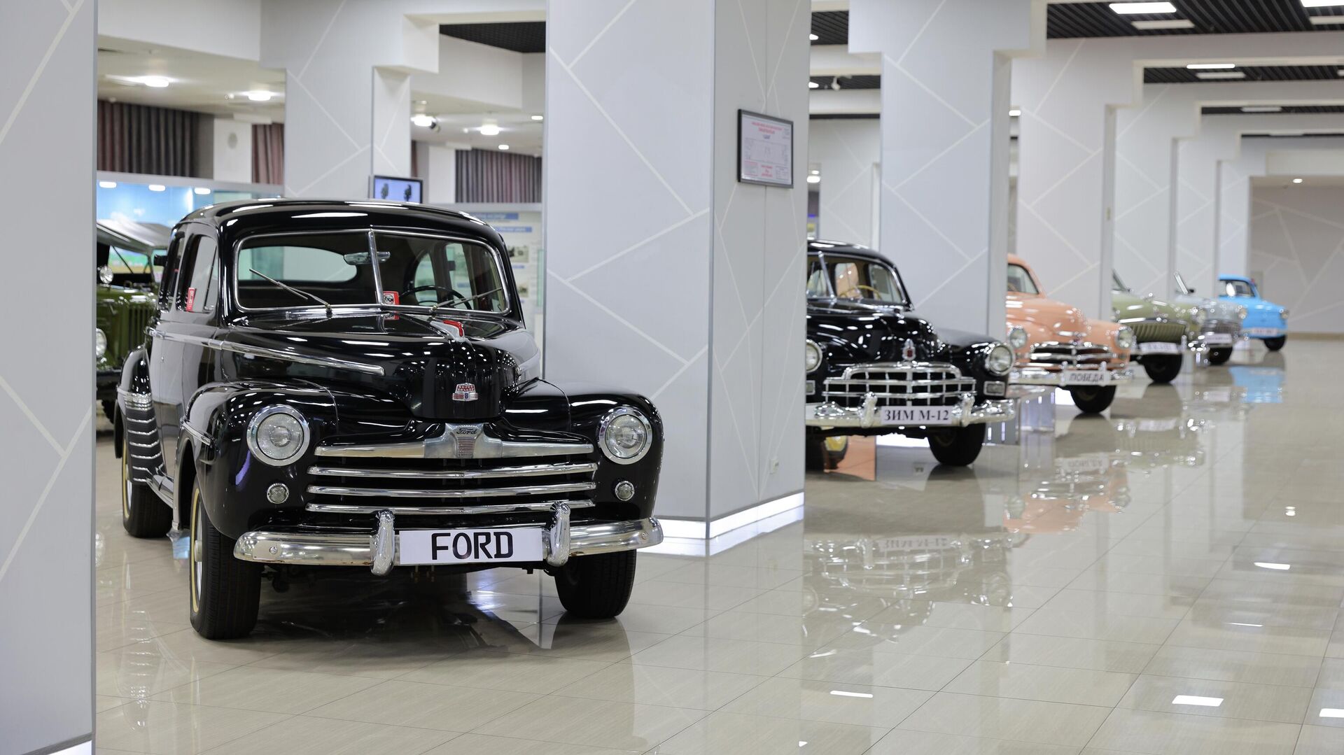 Ford V8 Super Deluxe (1946 г.): Черный седан на переднем плане — настоящая редкость. Этот экземпляр прошел полную десятилетнюю реставрацию и считается одним из немногих сохранившихся в Узбекистане в столь идеальном состоянии.
ЗиМ (ГАЗ-12): Следующий в ряду черный автомобиль представительского класса, выпускавшийся в СССР в 1950-х годах. Его легко узнать по характерной массивной хромированной решетке радиатора.
ГАЗ-М20 Победа: Далее можно заметить розовый (или коралловый) автомобиль — знаменитую Победу, которая стала символом послевоенного советского автопрома. Ford V8 Super Deluxe (1946 г.): Черный седан на переднем плане — настоящая редкость. Этот экземпляр прошел полную десятилетнюю реставрацию и считается одним из немногих сохранившихся в Узбекистане в столь идеальном состоянии.
ЗиМ (ГАЗ-12): Следующий в ряду черный автомобиль представительского класса, выпускавшийся в СССР в 1950-х годах. Его легко узнать по характерной массивной хромированной решетке радиатора.
ГАЗ-М20 Победа: Далее можно заметить розовый (или коралловый) автомобиль — знаменитую Победу, которая стала символом послевоенного советского автопрома. - Sputnik Узбекистан, 1920, 16.02.2026