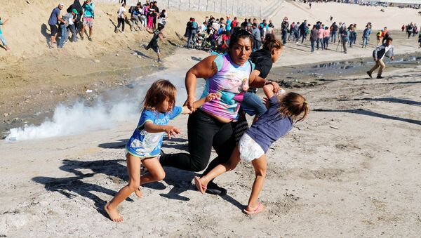 Мигранты из Гондураса бегут от слезоточивого газа, распыленного американскими пограничниками - Sputnik Ўзбекистон