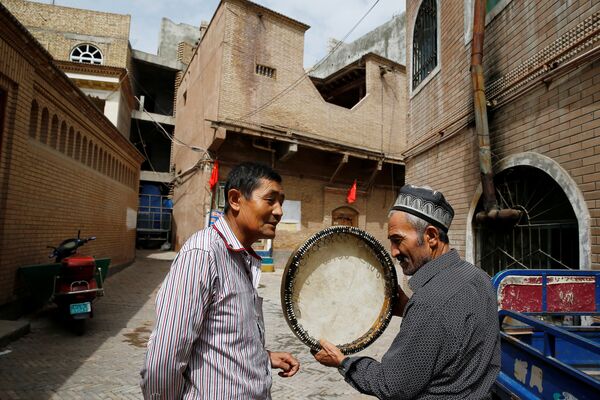 Мужчина продает музыкальный инструмент в Старом городе в Кашгаре, Синьцзян-Уйгурский автономный район, Китай - Sputnik Узбекистан