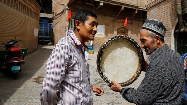 Мужчина продает музыкальный инструмент в Старом Городе в Кашгаре, Синьцзян-Уйгурский автономный район, Китай - Sputnik Ўзбекистон