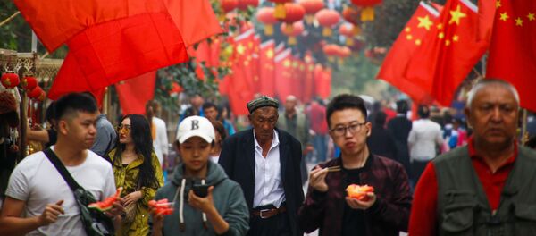 Lyudi proxodat mimo kitayskix flagov v Kashgare, Sinszan-Uygurskiy avtonomniy rayon, Kitay - Sputnik O‘zbekiston