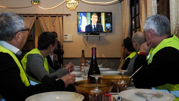 Протестующие смотрят выступление президента Франции Эммануэля Макрона по телевизору - Sputnik Узбекистан