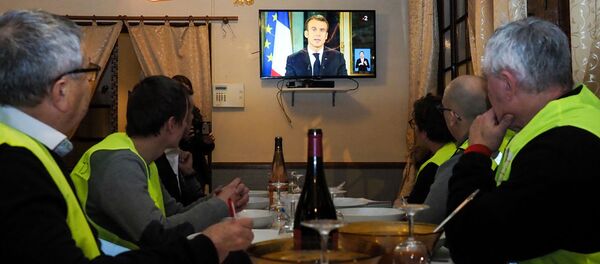 Протестующие смотрят выступление президента Франции Эммануэля Макрона по телевизору - Sputnik Узбекистан