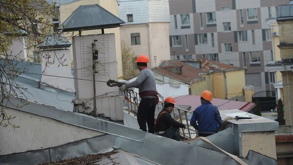 Рабочие-строители на крыше здания в Москве. - Sputnik Ўзбекистон