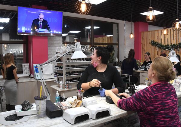 Женщины смотрят прямую трансляцию ежегодной большой пресс-конференции президента РФ Владимира Путина в салоне красоты во Владивостоке - Sputnik Узбекистан