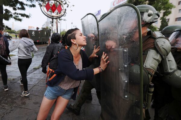 Активистка из племени Мапуче пытается остановить движение сотрудников полиции во время акции протеста в Сантьяго, Чили - Sputnik Узбекистан