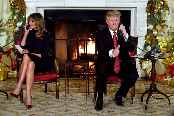 Президент США Дональд Трамп со супругой Меланией во время получения информации о прохождении Санты Клауса в канун Рождества - Sputnik Узбекистан