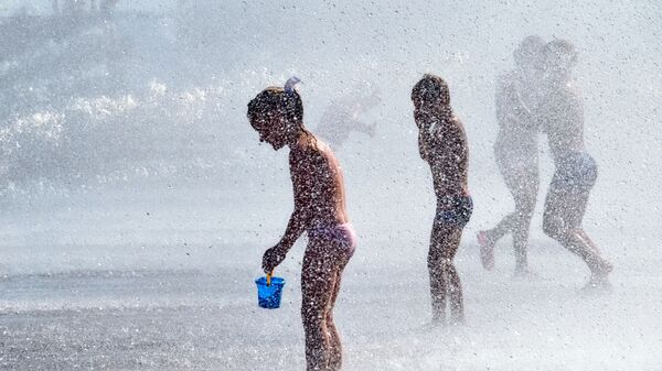 Горожане спасаются от жары в фонтане парка 300-летия Санкт-Петербурга. - Sputnik Ўзбекистон