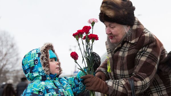Ребенок дарит цветы ветерану  - Sputnik Узбекистан