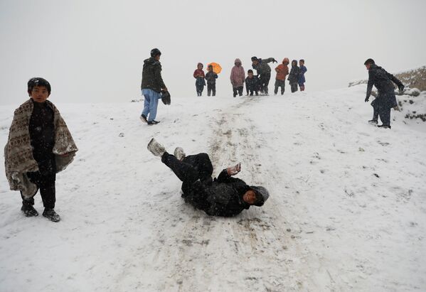 Дети катаются с горки во время снегопада в Кабуле - Sputnik Ўзбекистон