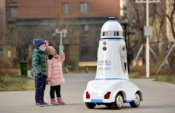 Дети рядом с роботом-патрульным на улице китайского города Хух-Хото, Внутренняя Монголия, Китай - Sputnik Узбекистан