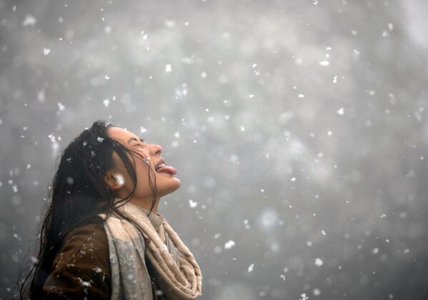 Девушка ловит ртом снежинки во время снегопада в Катманду, Непал - Sputnik Узбекистан