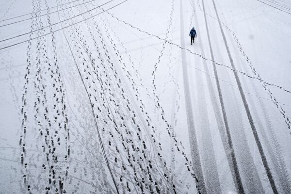 Прохожий во время снегопада в Парке Горького в Москве - Sputnik Узбекистан