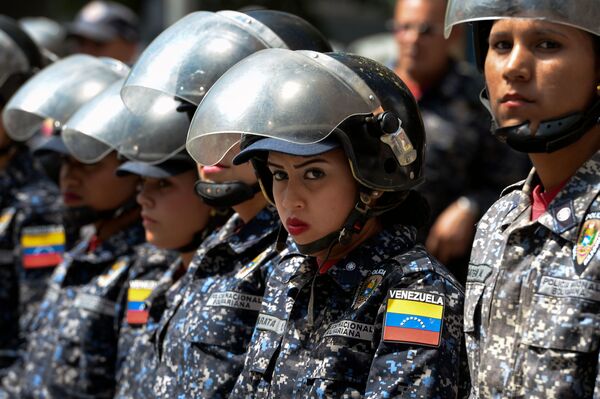 Полицейские во время акции протеста против президента Николаса Мадуро в в Каракасе, Венесуэла - Sputnik Узбекистан
