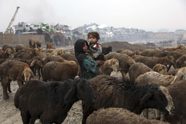Девушка-пастушка несет на руках свою сестру, Кабул, 2018 год - Sputnik Узбекистан