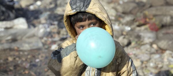 Афганский мальчик надувает воздушный шарик, окраина Кабула, Афганистан, 2017 год - Sputnik Ўзбекистон