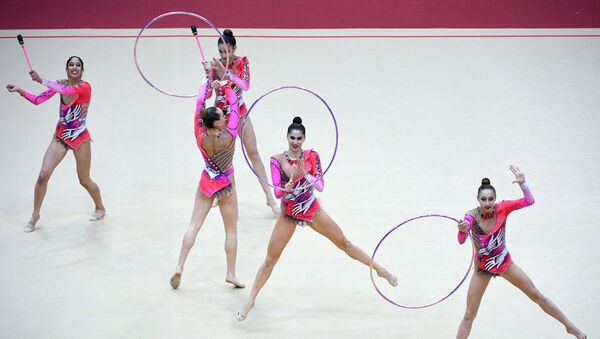 Команда Узбекистана выполняет упражнение с тремя обручами и двумя парами булав в финале групповой программы по художественной гимнастике на этапе Гран-при Москвы. - Sputnik Узбекистан