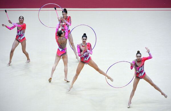 Команда Узбекистана выполняет упражнение с тремя обручами и двумя парами булав в финале групповой программы по художественной гимнастике на этапе Гран-при Москвы. - Sputnik Узбекистан