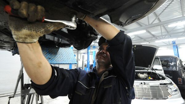 Сотрудник ремонтирует автомобиль - Sputnik Узбекистан
