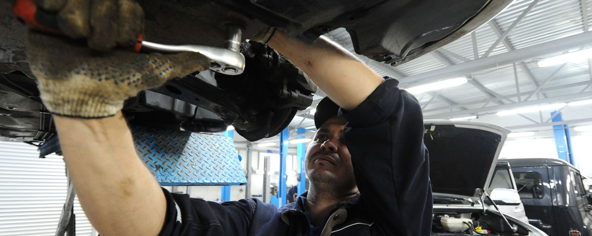 Сотрудник ремонтирует автомобиль - Sputnik Узбекистан, 1920, 09.12.2020