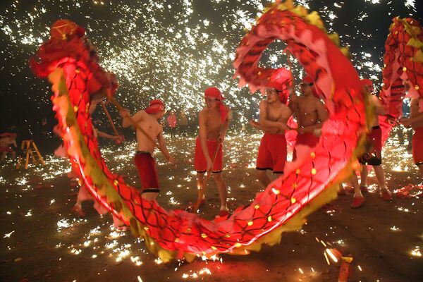 Народные артисты исполняют танец дракона во время Праздника фонарей в Аньшане, Китай - Sputnik Узбекистан