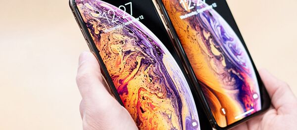 Мужчина держит телефон Apple iPhone Xs Мужчина держит телефон Apple iPhone Xs - Sputnik Узбекистан