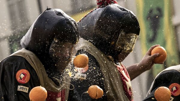 Люди бросают друг в друга апельсины во время традиционного фестиваля Битва апельсинов  - Sputnik Узбекистан