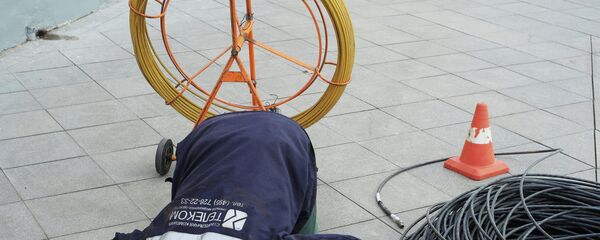 Рабочий прокладывает кабель Рабочий прокладывает кабель - Sputnik Узбекистан