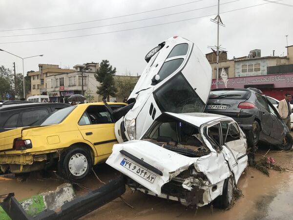 Перевернутые в результате наводнения автомобили в иранском городе Шираз - Sputnik Узбекистан
