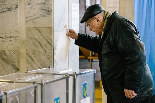 Житель Харькова на одном из избирательных участков города во время голосования на президентских выборах на Украине - Sputnik Узбекистан
