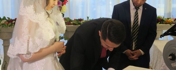 Молодожены расписываются на узбекской свадьбе Молодожены расписываются на узбекской свадьбе - Sputnik Ўзбекистон