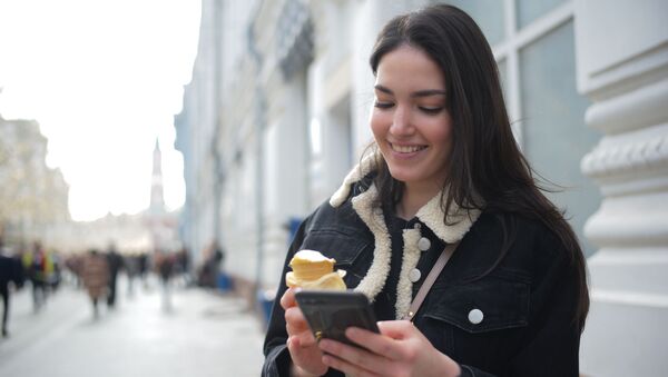 Девушка ест мороженое на Никольской улице в Москве. - Sputnik Ўзбекистон