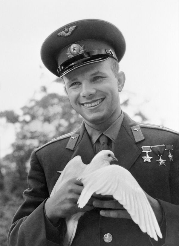 Летчик-космонавт Юрий Гагарин держит голубя, подаренного ему болгарскими пионерами - Sputnik Узбекистан