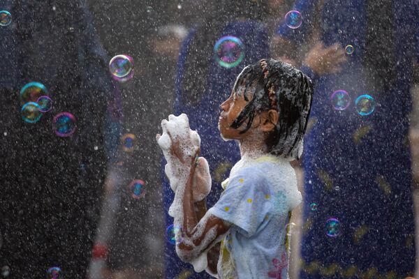 Девочка в окружении мыльных пузырей во время Бирманского новогоднего Водяного фестиваля в Янгоне, Мьянма - Sputnik Узбекистан
