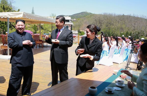 Лидер Северной Кореи Ким Чен Ын пьет чай с председателем КНР Си Цзиньпином в китайском городе Далянь - Sputnik Узбекистан
