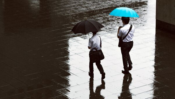 Люди идут с зонтами под дождем - Sputnik Узбекистан