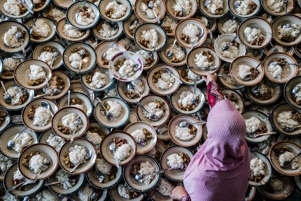 Индонезийская женщина подготавливает мусульманский ужин во время Рамадана в мечети Йогокарян в городе Джокьякарта, 11 мая 2019. - Sputnik Узбекистан