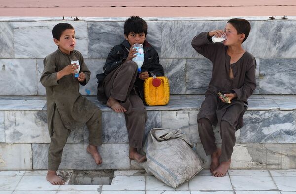 Афганские мальчики пьют напиток на основе йогурта во внутреннем дворе Голубой мечети в городе Мазари-Шариф во время Рамадана. - Sputnik Узбекистан