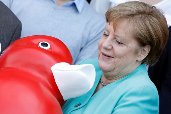 Канцлер Германии Ангела Меркель держит уточку, подаренную ей во время визита в компанию Centogene в городе Росток - Sputnik Узбекистан