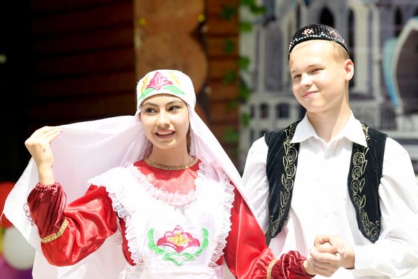 Парень и девушка в татарских национальных костюмах жениха и невесты на празднике Сабантуй в Ташкенте - Sputnik Узбекистан