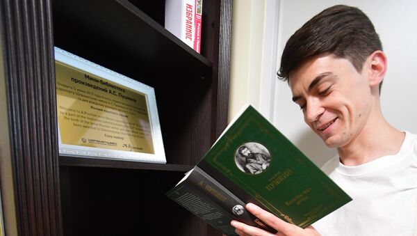 Молодой человек читает книгу из мини-библиотеки - Sputnik Узбекистан