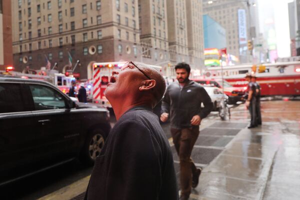 Мужчина наблюдает за местом падения вертолета на небоскреб в Нью-Йорке. - Sputnik Узбекистан