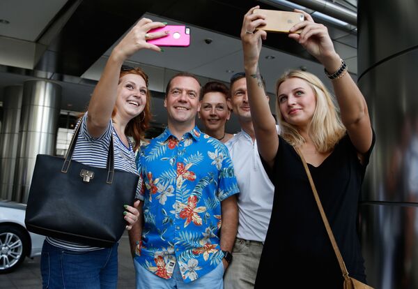 Премьер-министр России Дмитрий Медведев во время фотографирования с российскими и украинскими туристами в Куала-Лумпуре  - Sputnik Узбекистан