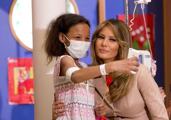Девочка делает селфи с первой леди США Меланией Трамп в детской больнице Queen Fabiola в Брюсселе - Sputnik Узбекистан